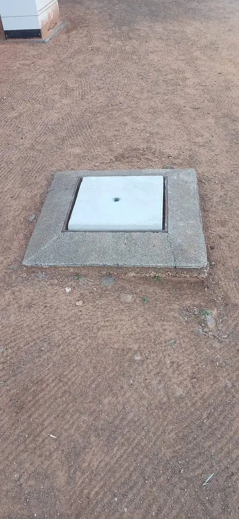Precast concrete manhole cover set into the ground